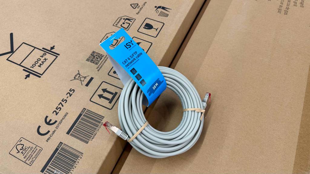 Ein Cat6-Kabel liegt zum testen auf einem Karton.