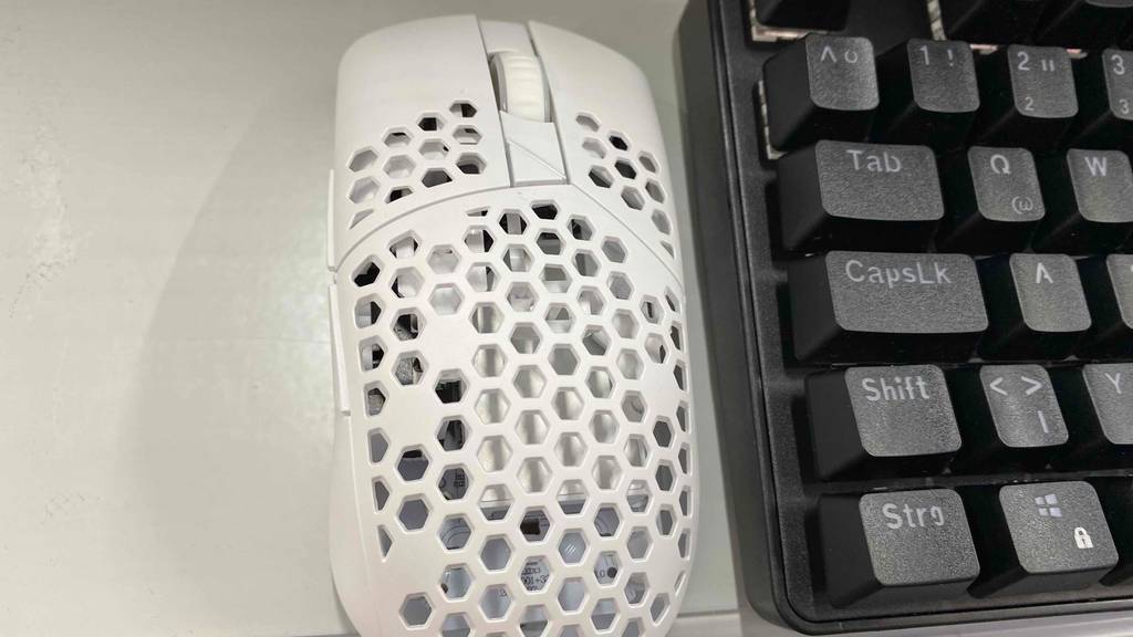 Eine kabellose Gaming-Maus liegt zum testen neben einer Tastatur.