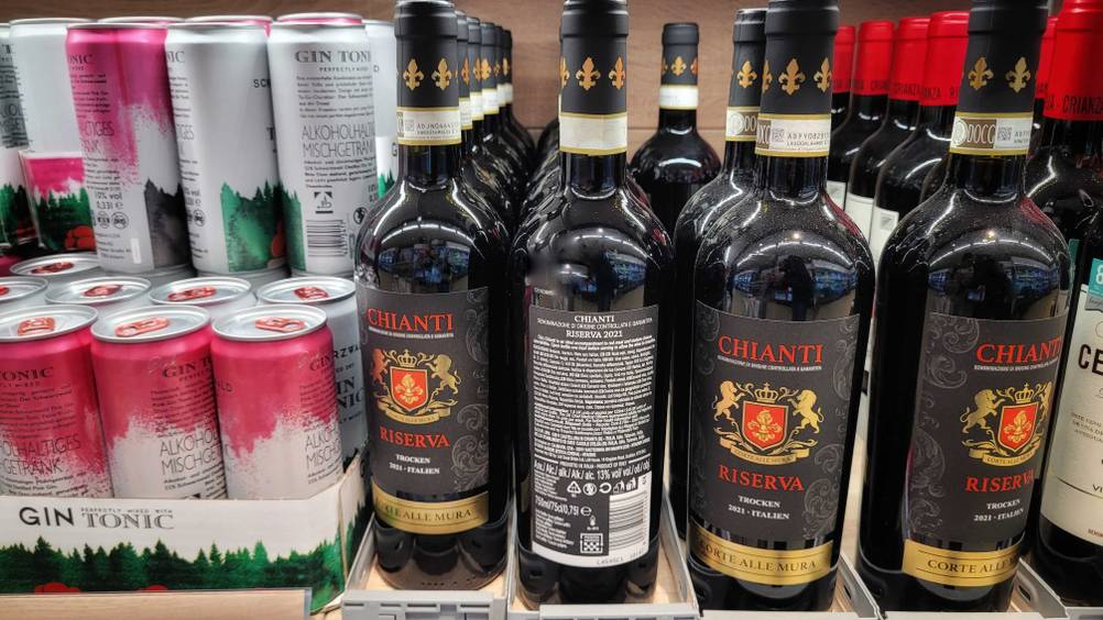 Mehrere Flaschen des getesteten ialienischen Rotweins in einem Regal neben anderen Produkten.