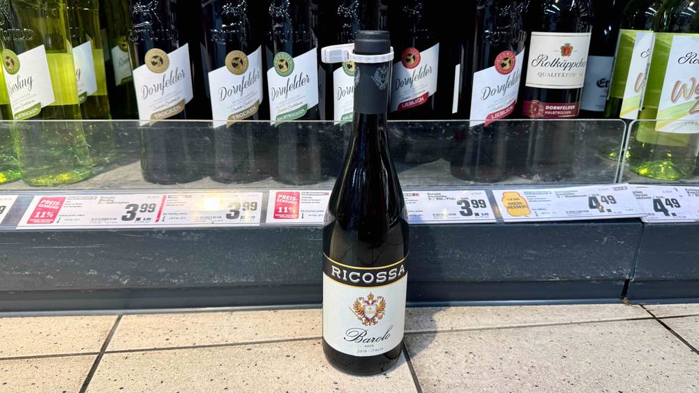 Eine Flasche des italienischen Weins im Test vor einem Verkaufsregal mit Preisangaben.
