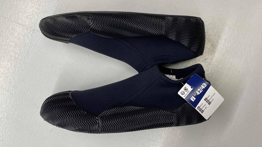 Im Test: Itiwit Neoprenschuhe für Herren in schwarz liegen seitlich auf weißer Fläche.