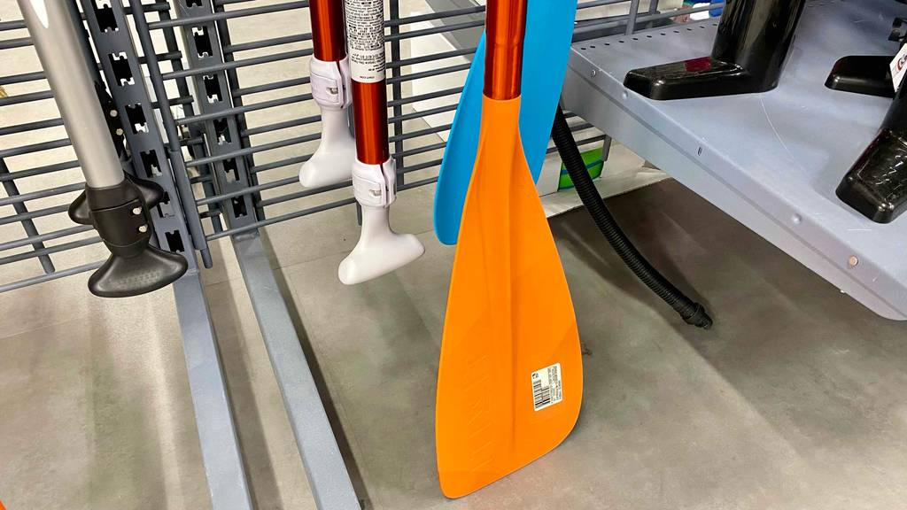 SUP-Paddel-Test: Nahaufnahme eines Paddels in einem Regal vor anderen Produkten stehend.