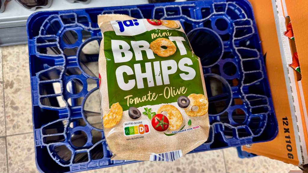 Brotchips-Test: Eine Packung mit Tomate-Oliven-Geschmack liegt auf einem Korb.
