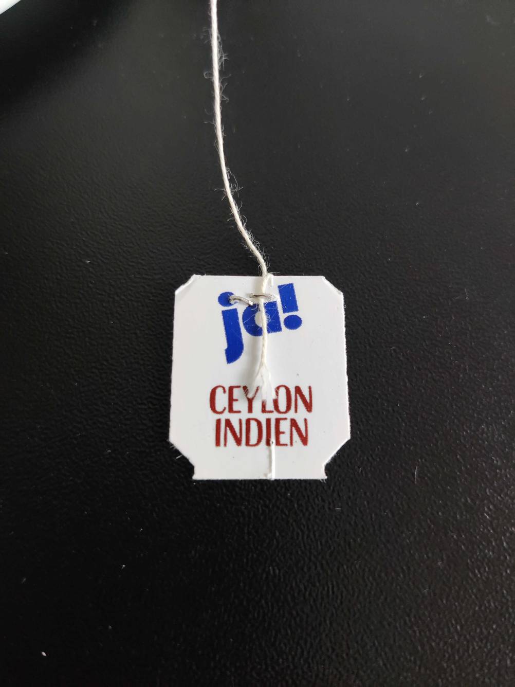 Ceylon-Tee getestet: Nahaufnahme des Teeetikettes von oben auf einer dunklen Fläche.