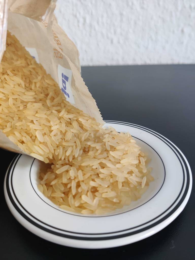 Langkornreis im Test aus der Tüte auf einen Teller geschüttet.