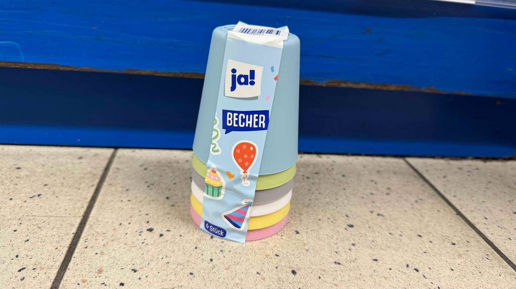 Plastikbecher im Test: Sechs Plastikbecher in unterschiedlichen Farben stehen übereinandergestapelt auf dem Boden.