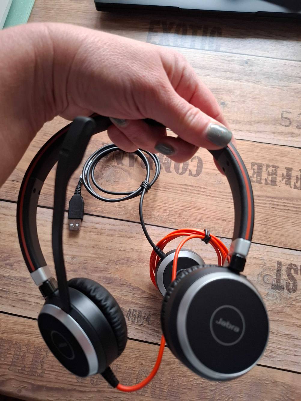 Eine Hand hält ein Jabra-Headset zum testen.