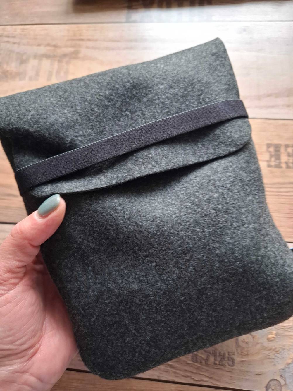 Eine Hand hält den grauen Aufbewahrungsbeutel für ein getestetes Jabra-Headset.