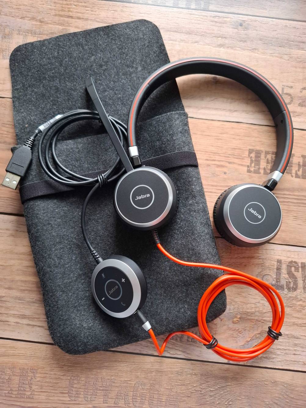 Jabra-Headset im Test: Ein Set mit Kabel und Tasche liegt auf einer Holzfläche.