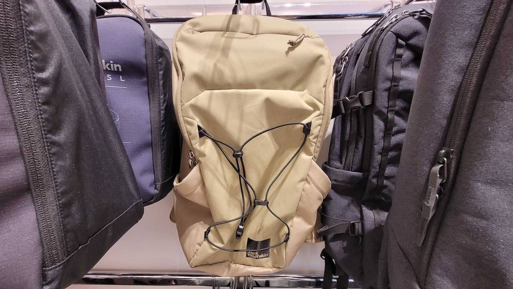 Ein Jack-Wolfskin-Rucksack im Test in beige in einem Verkaufsregal hängend.
