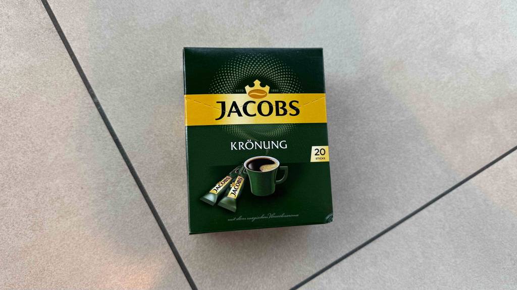 Kaffee-Sticks im Test: Eine grüne Packung Jakobs Krönung mit 20 Sticks liegt auf dem Boden.