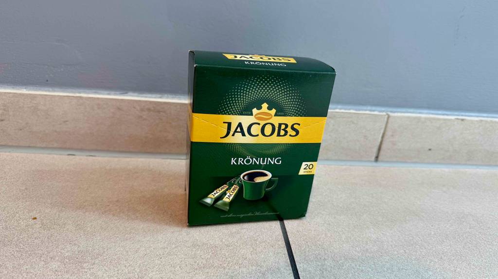 Getestete Kaffee-Sticks in der grünen Packung Jakobs Krönung mit 20 Sticks stehen auf dem Boden.