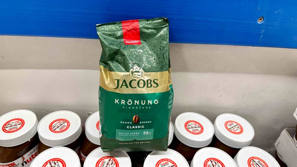 Eine Packung Jacobs Kaffeebohnen steht zum testen auf mehreren Gläsern Schokoaufstrich.