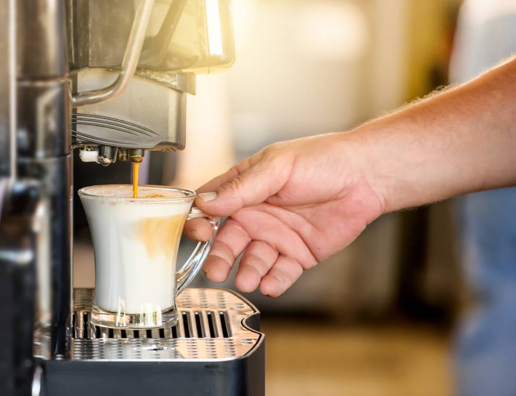 Jacobs-Kapseln-Test: Ein Mann macht sich einen Milchkaffee in einer Maschine. 