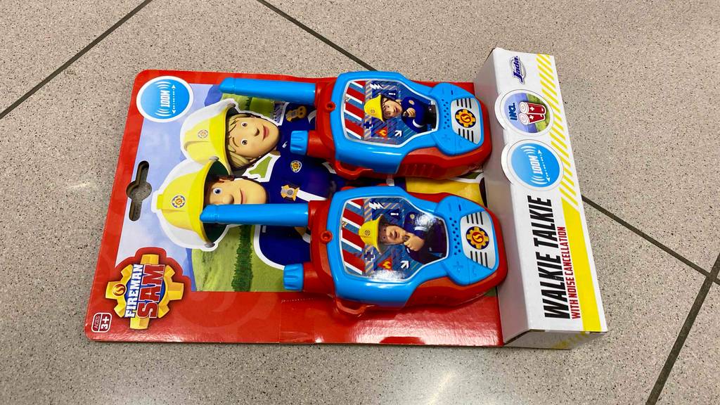 Im Test: Walkie-Talkies für Kinder im Feuerwehrmann-Design liegen in ihrer Verpackung auf einem hellen Fliesenboden.