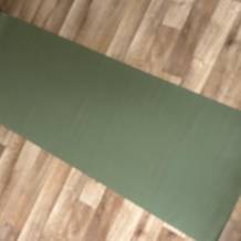 Grüne Yogamatte auf dem Boden.