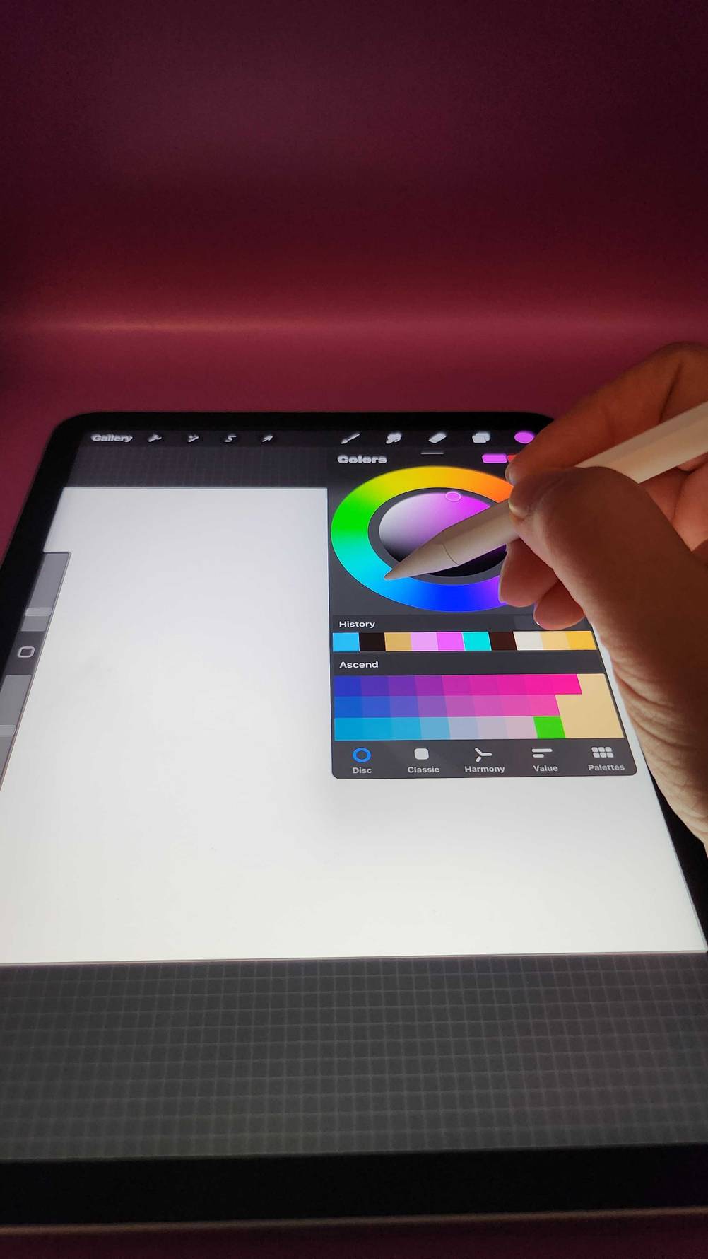 Eine Hand wählt mit einem getesteten iPad Stylus Pen im Bildbearbeitungsprogramm eine Farbe des Farbkreises.