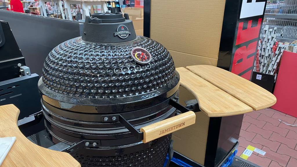 Keramikgrill-Test: ein schwarzes Modell von Jamestown mit seitlichen Ablageflächen steht geschlossen in einem Verkaufsbereich.