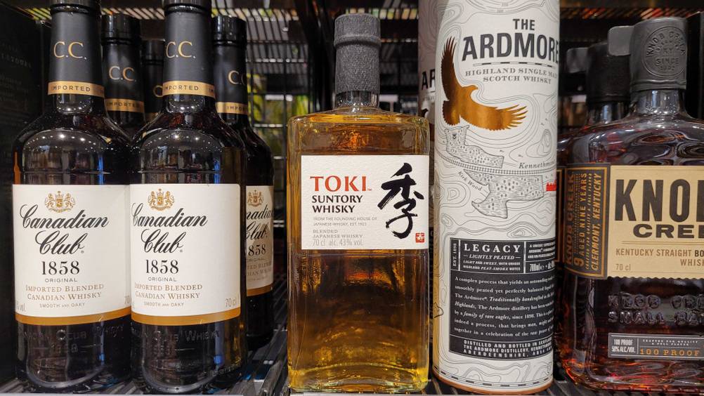 Eine Flasche des getesteten Japanischen Whiskys steht zwischen anderen Produkten in einem Regal.