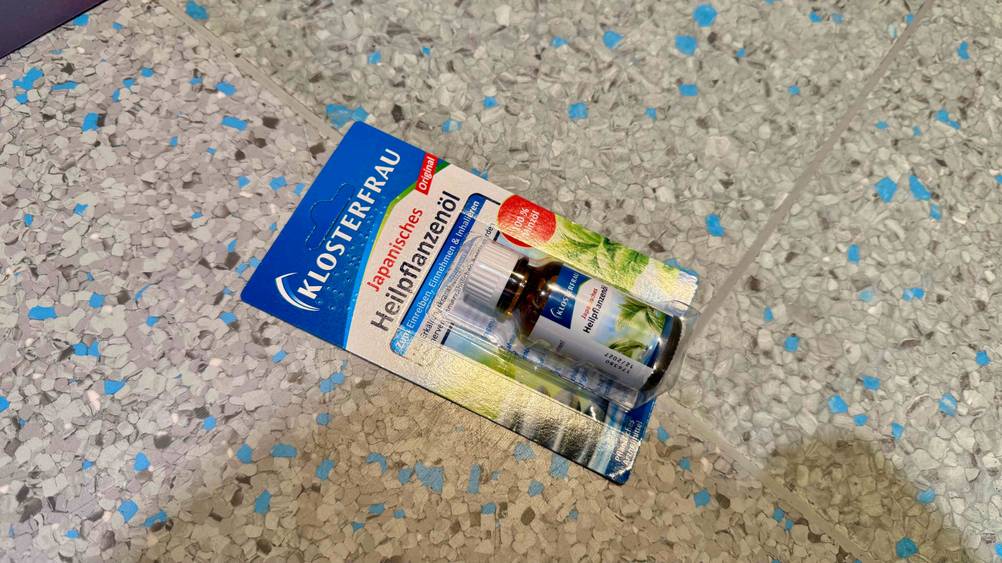 Auf einem grauen Boden liegt ein verpacktes japanisches Heilpflanzenöl im Test.