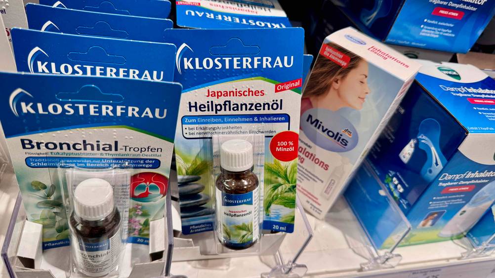 Mehrere Packungen des japanischen Heilpflanzenöls im Test in einem Verkaufsregal neben anderen Produkten.
