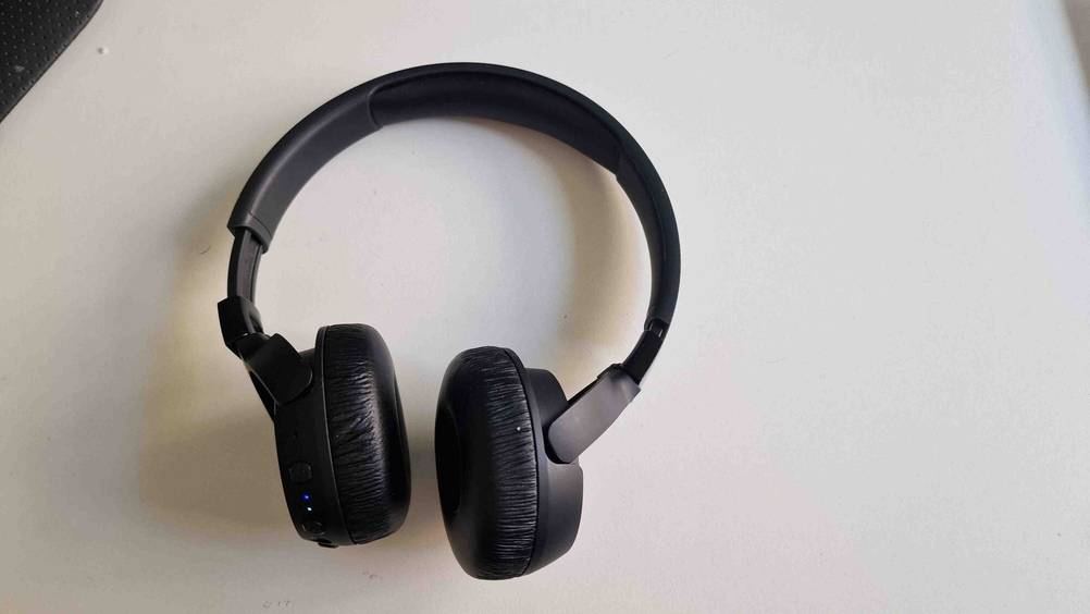 Die getesteten JBL-Bluetooth-Kopfhörer von oben auf einem hellen Untergrund liegend.