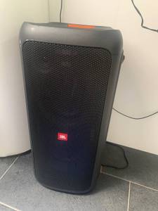 Ein schwarzer JBL-Bluetooth-Lautsprecher im Test auf grauen Fliesen.