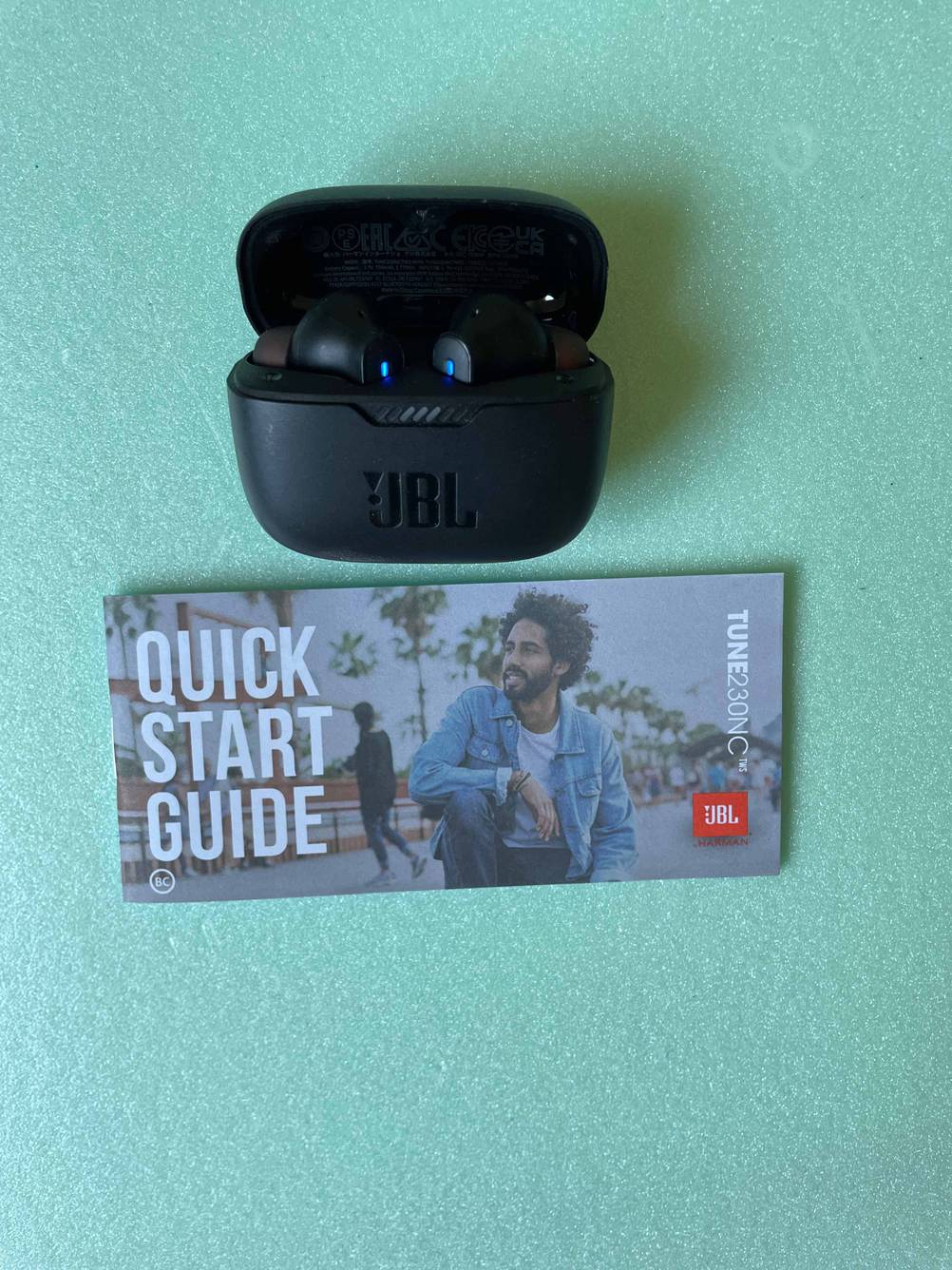 Getestete JBL-In-Ear-Kopfhörer befinden sich vor dem passenden Quick-Start-Guide. 