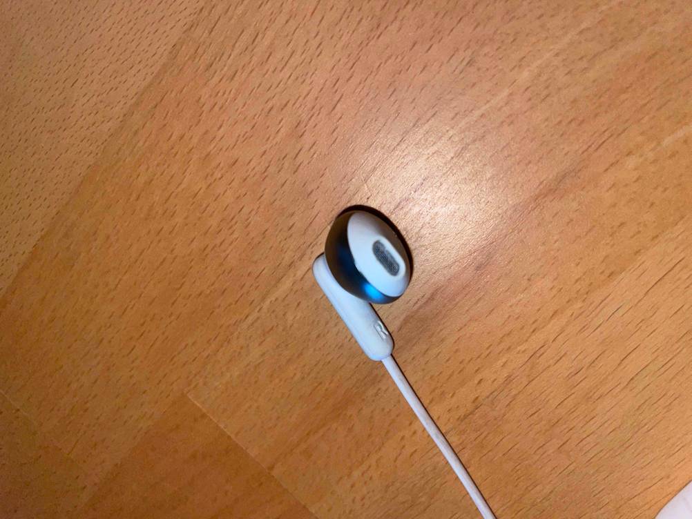 Eine Hörmuschel von getesteten JBL-Kopfhörern liegt auf dem Boden. 