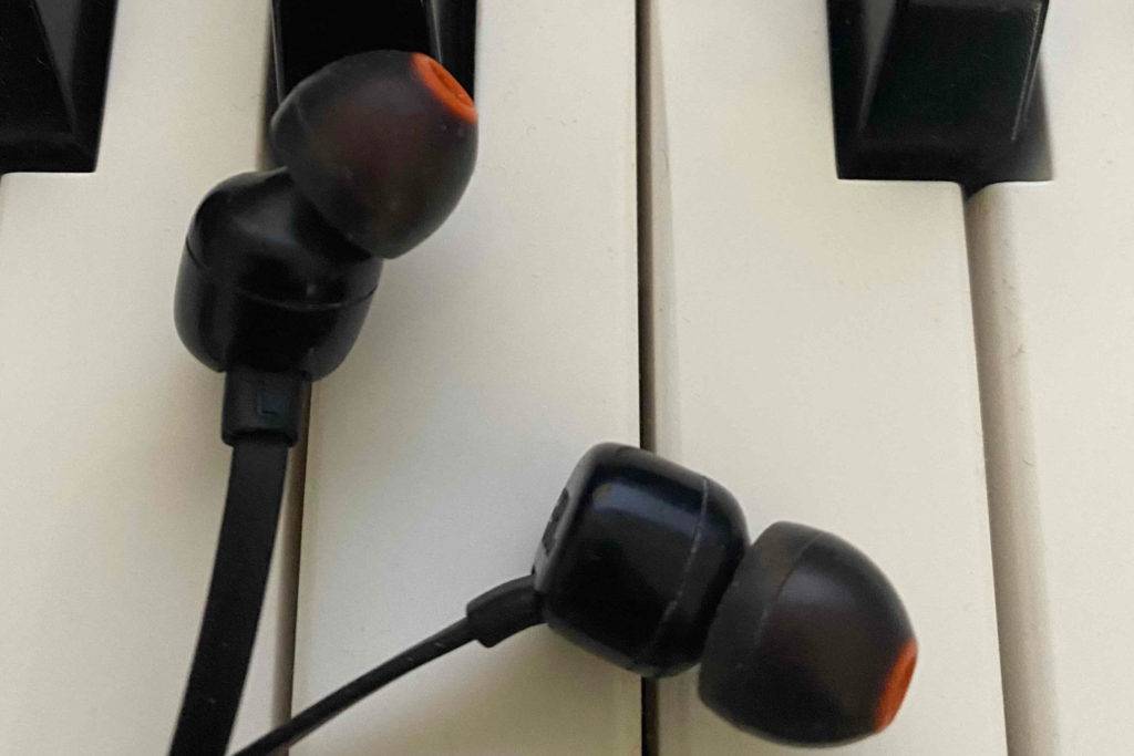 Die getesteten Kopfhörer liegen auf einem Keyboard.