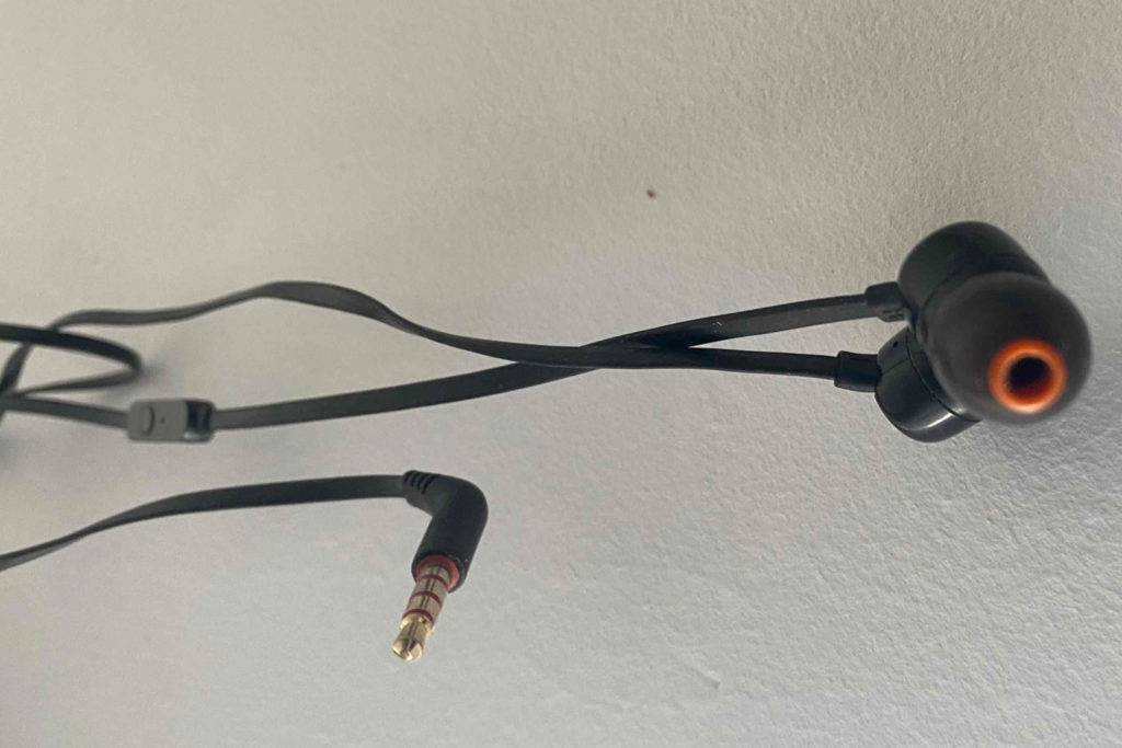 Die getesteten Kopfhörer hängen vor einer Wand.