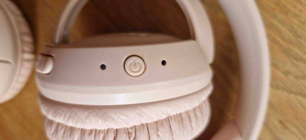 Bluetooth-Kopfhörer-On-Ear-Test: Nahaufnahme einer Ohrmuschel von einem rosa Modell der Marke JBL mit Einschalttaste.