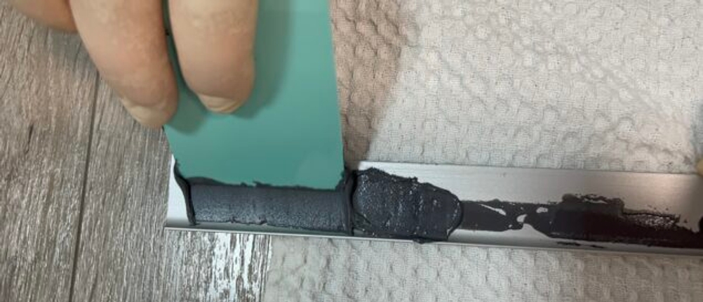 Der Metallkleber von J-B Weld wird mit einem Hilfsgerät aufgetragen.