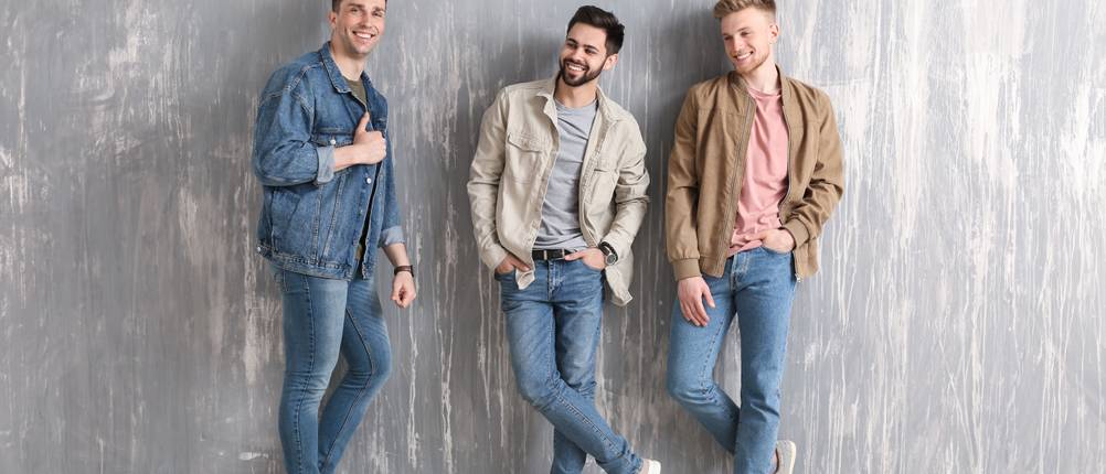 Jeans-Herren-Test: drei Männer in Jeans vor grauer Wand