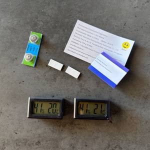 Der Lieferumfang vom Jedew-Hygrometer liegt auf einem Tisch