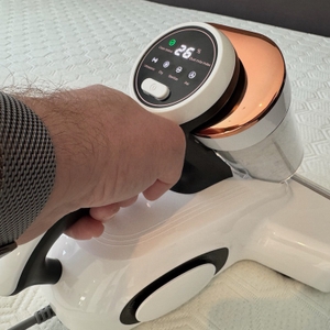 Eine Hand reinigt eine Matratze mit dem Jigoo J300