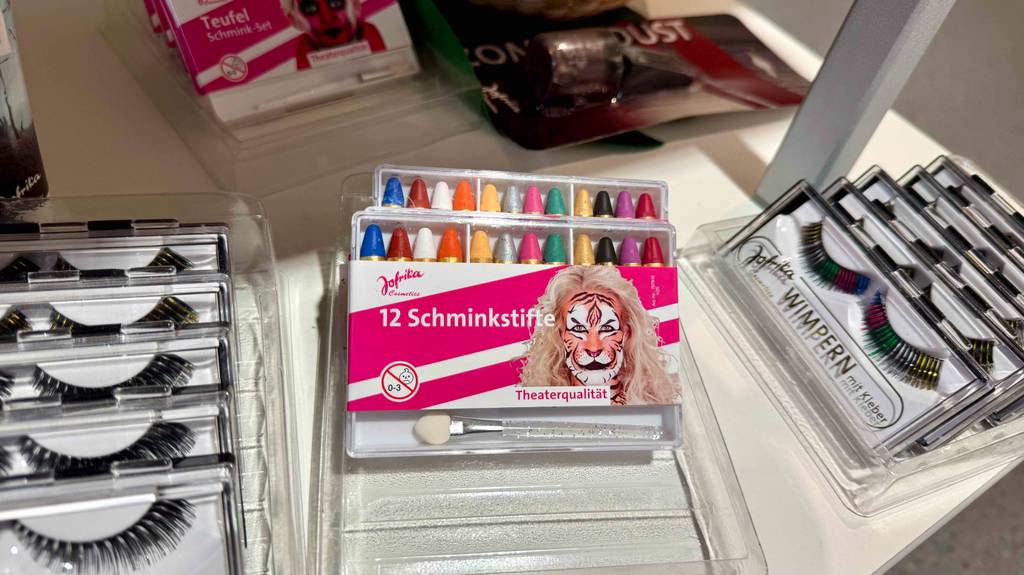 Schminkstifte im Test: Zwei Packungen liegen aufeinander zwischen künstlichen Wimpern.
