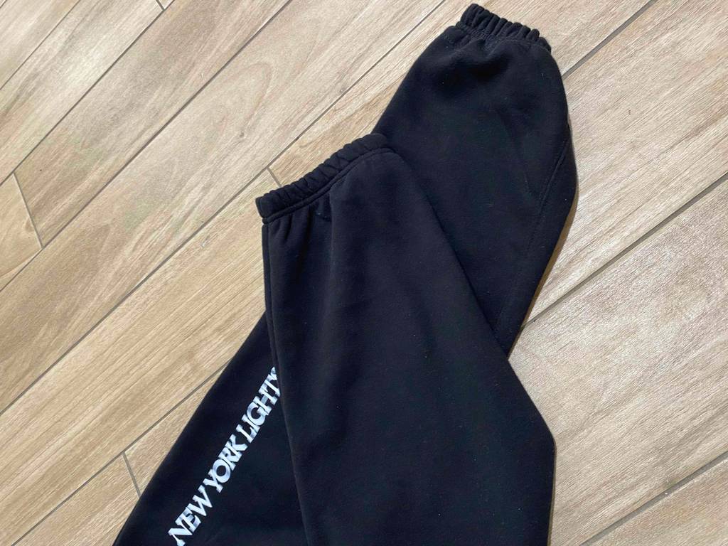 Jogginghose Herren im Test: Nahaufnahme der Beine auf einem Holzuntergrund.