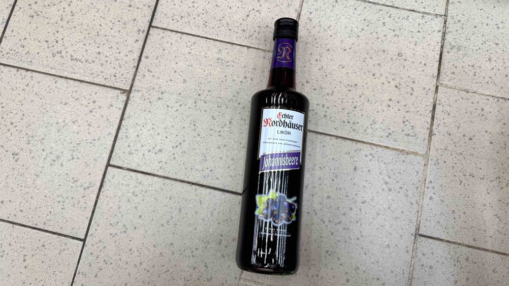 Johannisbeerlikör im Test: Eine Flasche von oben auf einem Fließenboden.