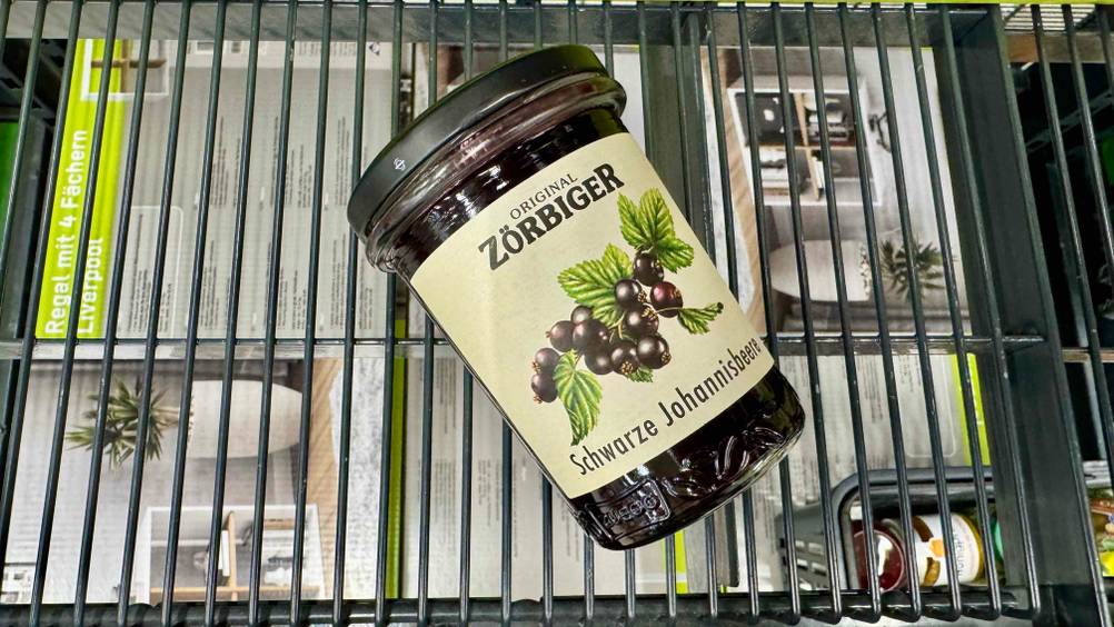 Auf einem Gitter liegt ein Glas der Johannisbeermarmelade im Test.