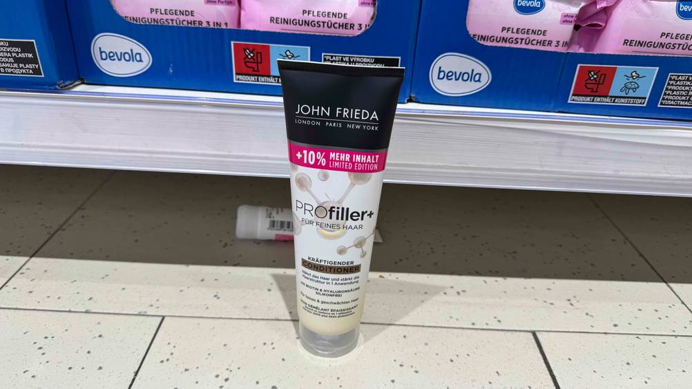 Vor einem Verkaufsregal steht eine Tube des getesteten John-Frieda-Conditioners auf dem Boden.