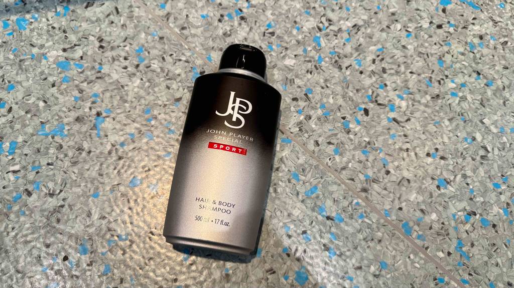 Eine Flasche getestetes 2-in-1-Shampoo liegt auf einem gesprenkelten Boden.