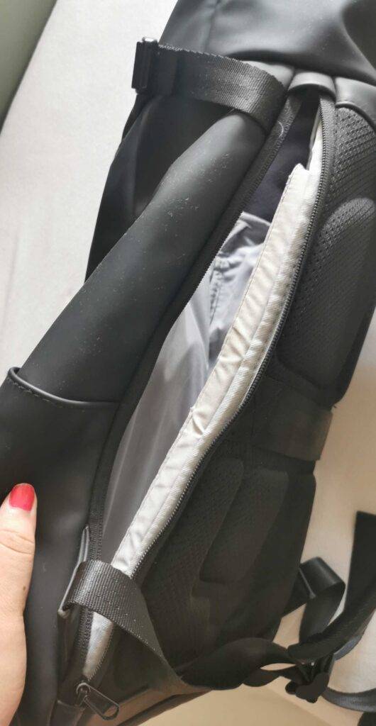 Detailansicht auf ein vor der Rückenpolsterung befindliches Fach, inklusive Reißverschluss, von einem grauen Handgepäck-Rucksack im Test.