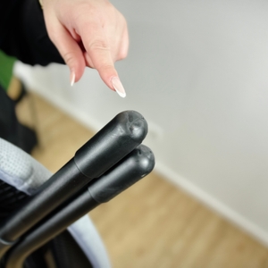 Eine Hand zeigt auf die Anti-Rutsch-Kappen aus Gummi an den Füßen des Joseph-Joseph-Ltd.-Bügelbretts.