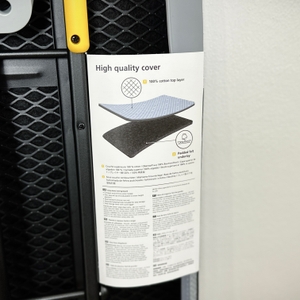 Eine Nahaufnahme der rechten Seite der Verpackung des Joseph-Joseph-Ltd.-Bügelbretts zeigt die Beschreibung des hochwertigen Bügelbrettbezugs. Die Materialzusammensetzung und die Polsterung werden erklärt.