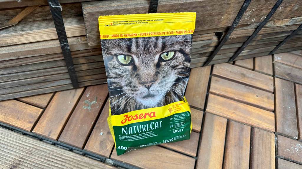Eine Packung getestetes Trockenfutter für die Katze getreidefrei steht auf einem Holzboden.