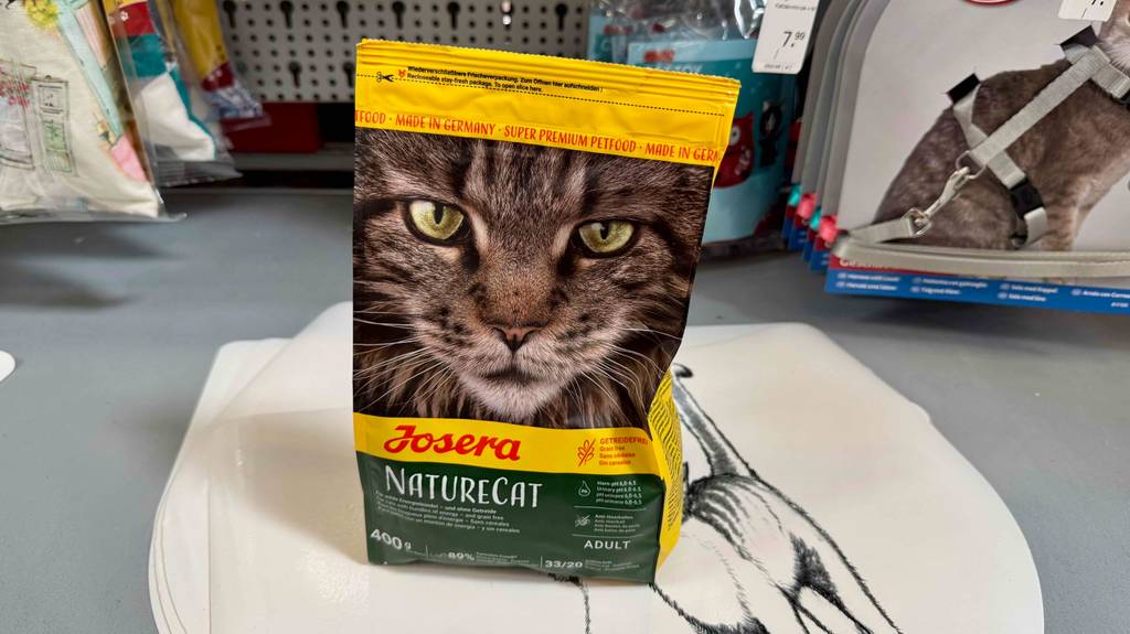 Eine Packung Trockenfutter für die Katze getreidefrei steht zum testen in einem Regal zwischen anderen Tierprodukten.
