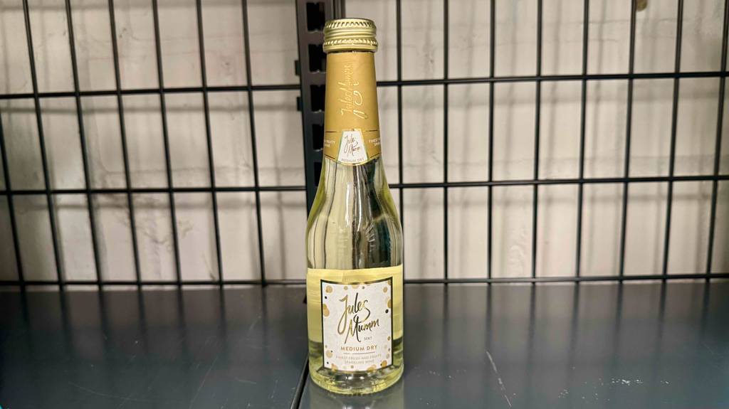 Eine Portionsflasche mit halbtrockenem Sekt im Test steht in einem Einkaufskorb.