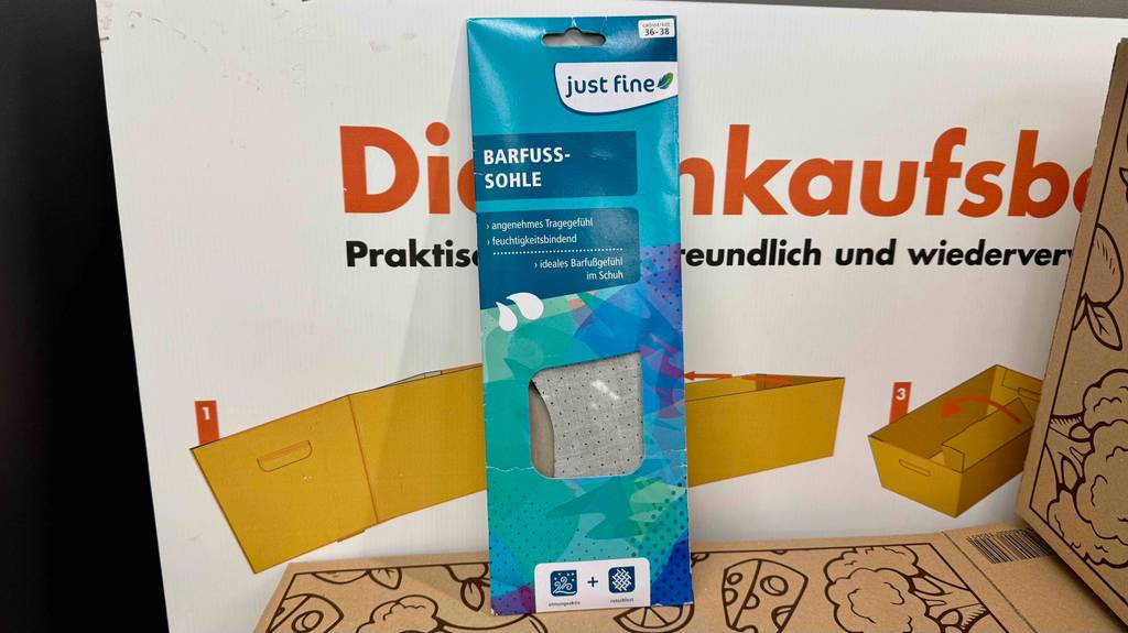 Getestete Barfußsohlen befindet sich in der blauen Verpackung vor einer Faltschachtel.