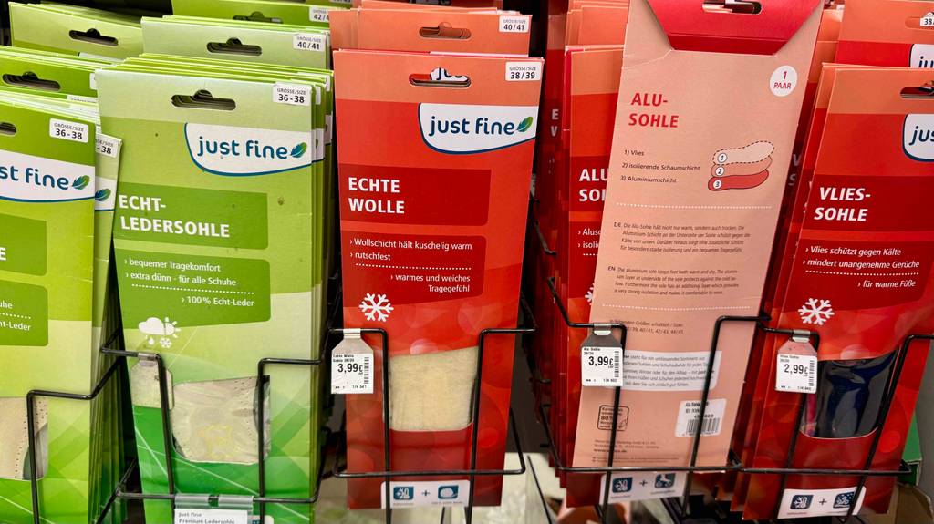 Mehrere Wärmesohlen im Test befinden sich in roten Verpackungen auf einem Verkaufsstand.